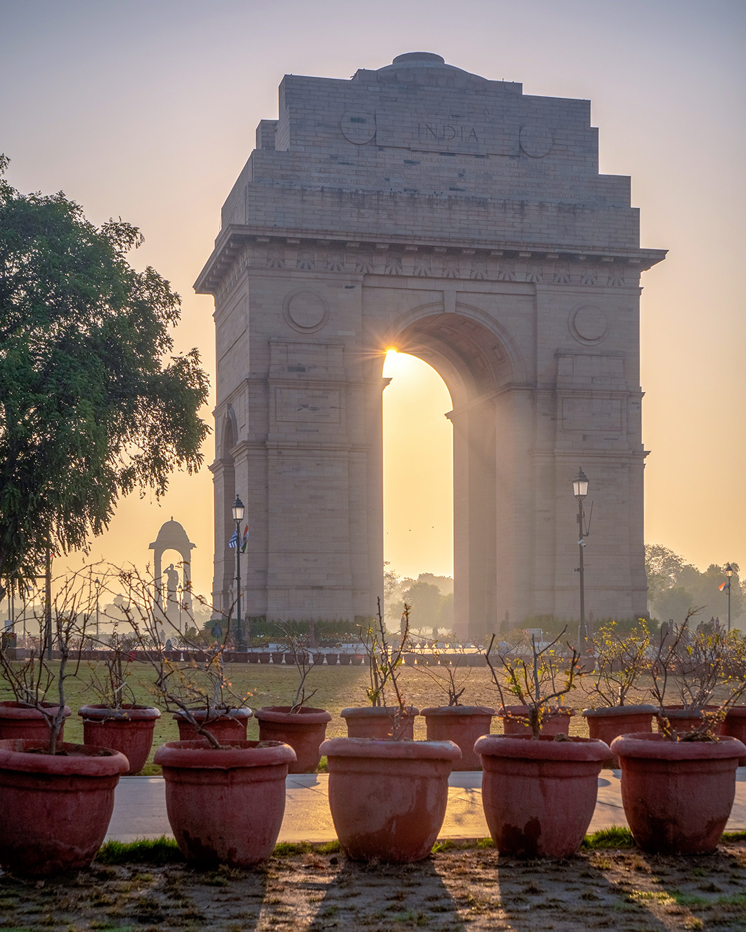 The morning sun peeking through the opening of India Gate, not too long after sunrise, in New Delhi, India.⁠
⁠
Completed in 1931, this 138-foot (42 m) tall triumphal arch was built as a war memorial to the British Indian Army soldiers who died during World War I and the Third Anglo-Afghan War, with over 13,000 names of those who died inscribed in its stone. It is primarily built from yellow and red Bharatpur sandstone, with its base being made of granite. The current statue featured behind it (and to the left in this photo) is also made of granite, dedicated to Netaji Subhas Chandra Bose, installed in 2022.⁠
⁠
I arrived here early this morning, prior to sunrise, setting up dead-center and further away from the monument, taking a photo I previously posted here, featuring the sun just above the horizon and to the right of the monument. After the sun rose, I wanted to get a shot of the sun itself visible through its center, with its light beaming outward like a massive spotlight. Using an app on my phone, I looked at the sun’s future path, set up my tripod in a position that would accomplish this, and waited for this moment to take place.